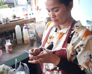 Asian lady seller looking at her handphone