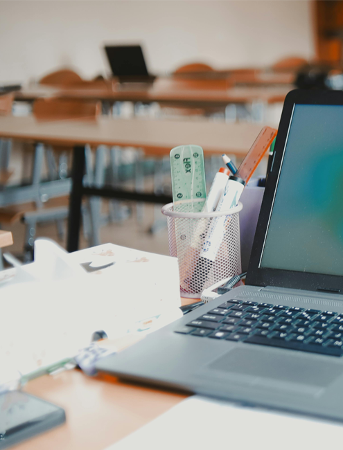 computer laptop with stationery in a classroom